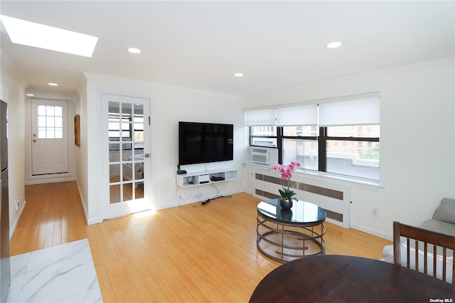 living room with a skylight, plenty of natural light, radiator, and crown molding