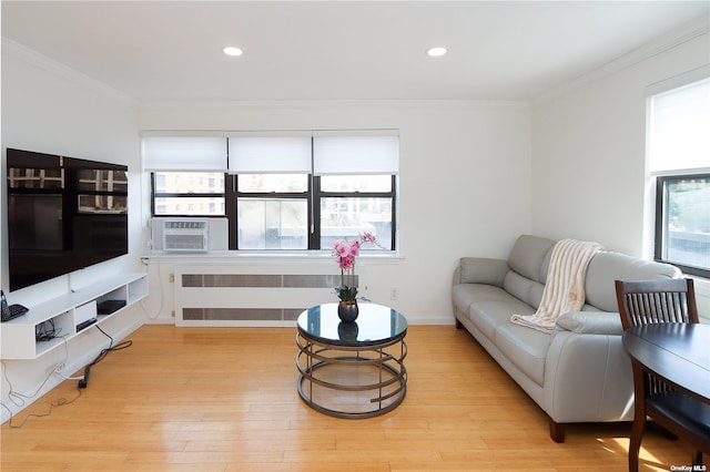 living room with radiator heating unit, light hardwood / wood-style floors, cooling unit, and ornamental molding