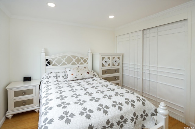 bedroom featuring ornamental molding and light wood-type flooring