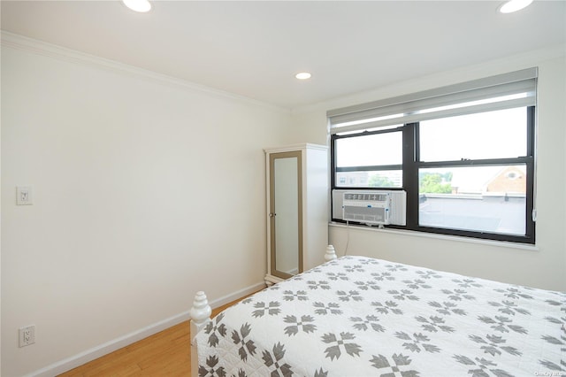 bedroom with hardwood / wood-style flooring, cooling unit, and ornamental molding