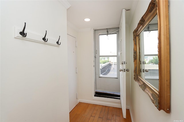 entryway with hardwood / wood-style flooring, plenty of natural light, and ornamental molding