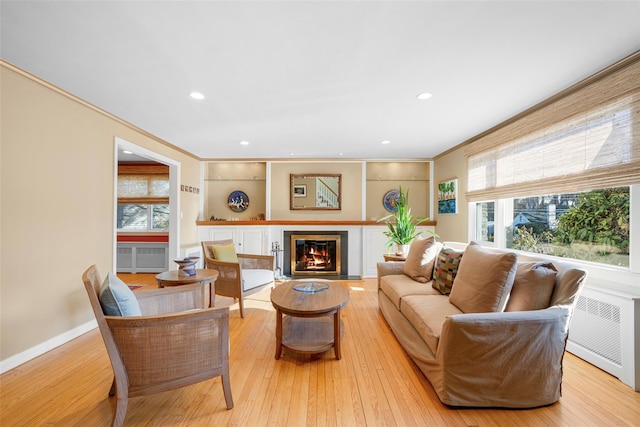 living room featuring light wood-type flooring and crown molding