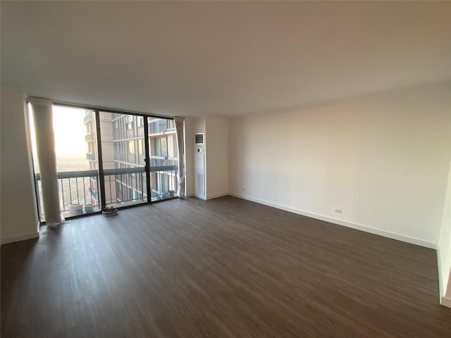 spare room with floor to ceiling windows and dark wood-type flooring