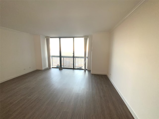 unfurnished room featuring floor to ceiling windows, ornamental molding, and dark hardwood / wood-style floors