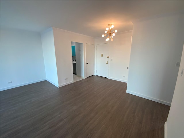 empty room with an inviting chandelier, ornamental molding, and dark hardwood / wood-style floors