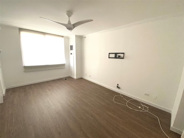 empty room with ceiling fan, crown molding, and dark wood-type flooring