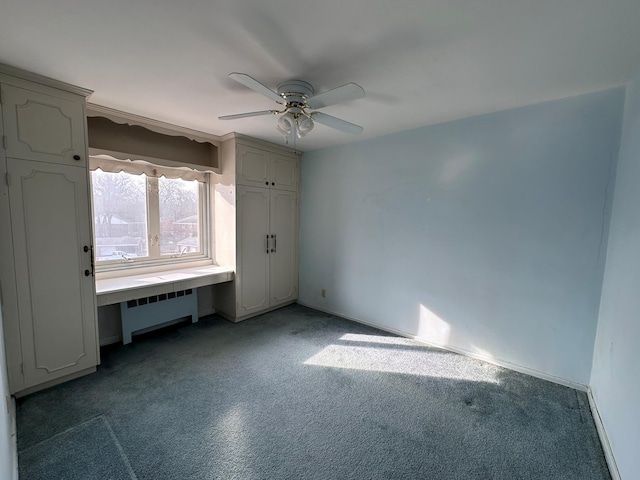 unfurnished bedroom with ceiling fan, radiator heating unit, and carpet floors