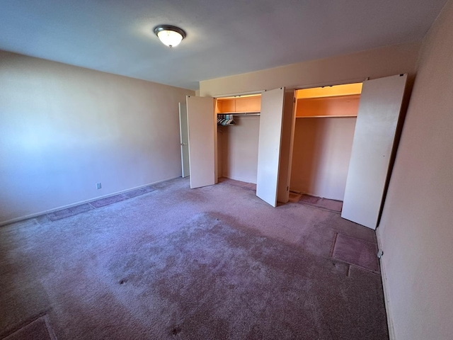 unfurnished bedroom with carpet and multiple closets