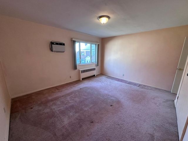 spare room with radiator heating unit and carpet floors