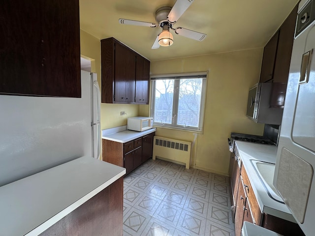 kitchen with radiator, ceiling fan, dark brown cabinets, and white appliances