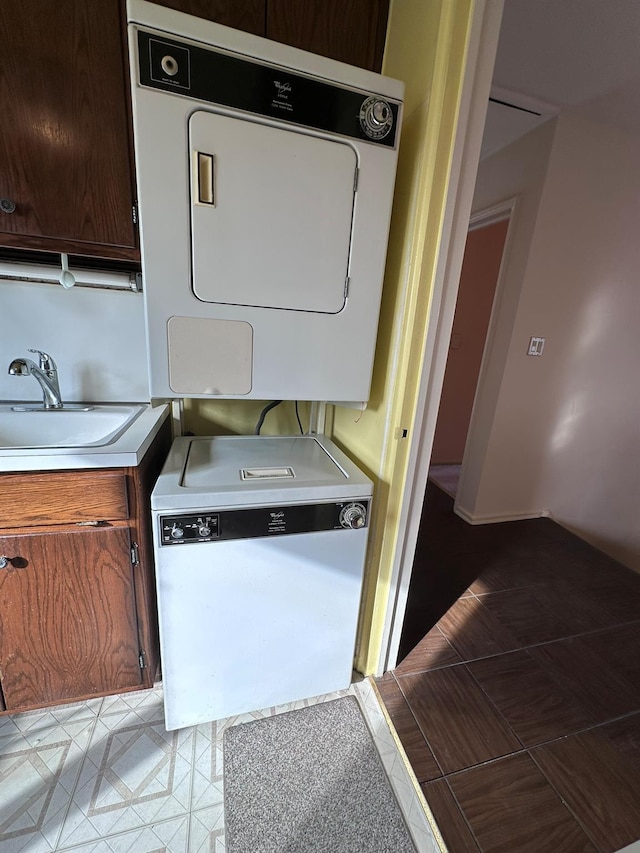 laundry area featuring sink and stacked washing maching and dryer