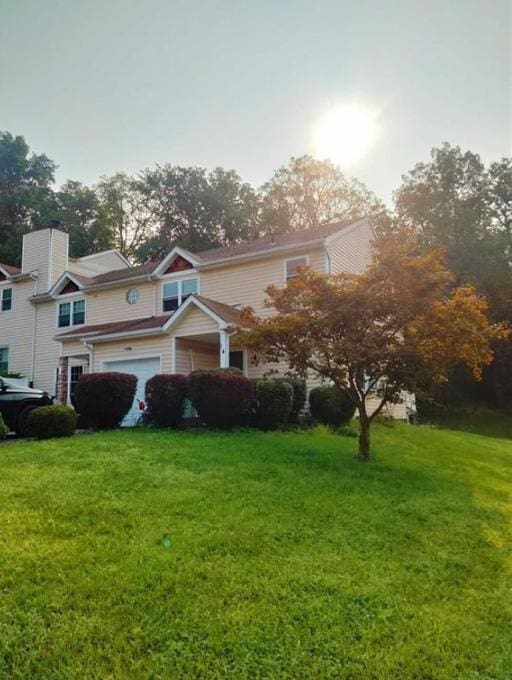 view of front of property featuring a front lawn and a garage