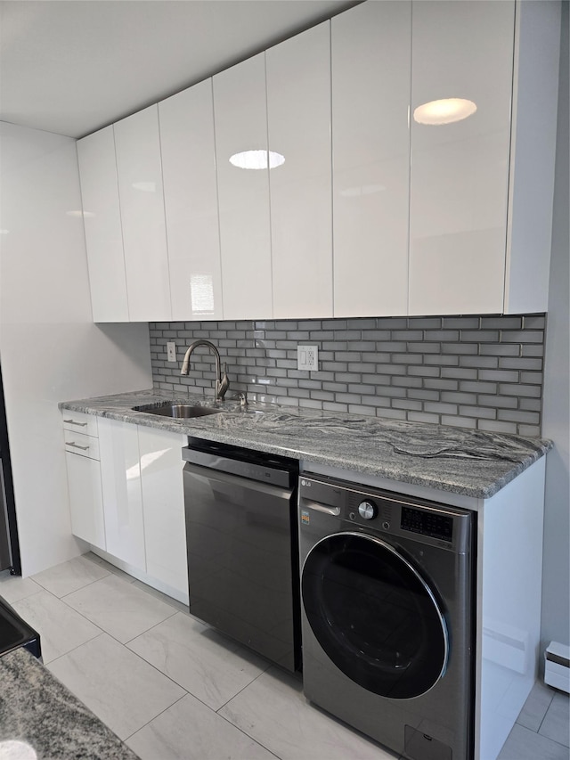 kitchen with dishwasher, white cabinets, sink, decorative backsplash, and washer / clothes dryer