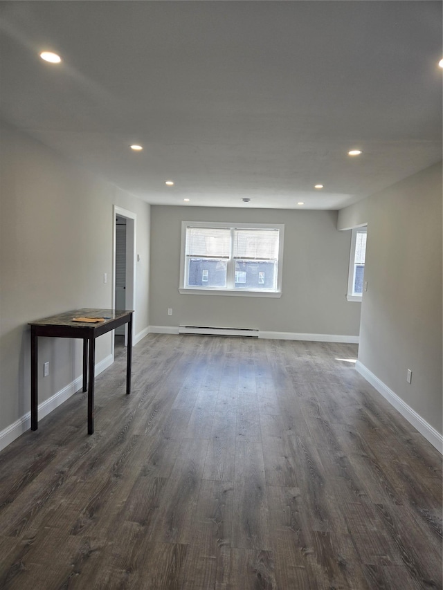 basement with dark hardwood / wood-style floors and a baseboard radiator