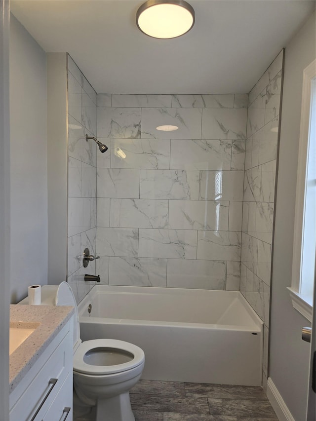 full bathroom featuring vanity, wood-type flooring, tiled shower / bath combo, and toilet