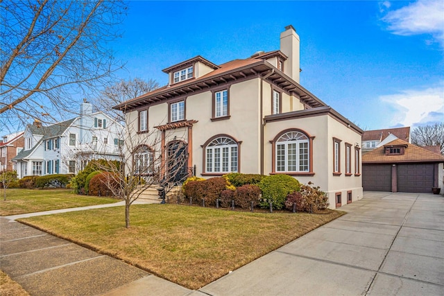 view of front facade featuring a garage, an outdoor structure, and a front yard