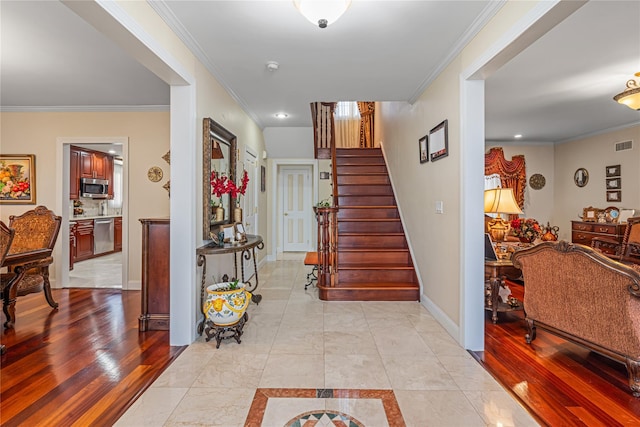 entrance foyer with light hardwood / wood-style flooring and crown molding