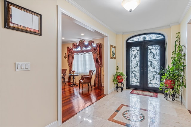 foyer entrance featuring ornamental molding, light tile patterned floors, and french doors