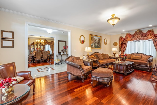 living room with crown molding, hardwood / wood-style floors, a healthy amount of sunlight, and a notable chandelier