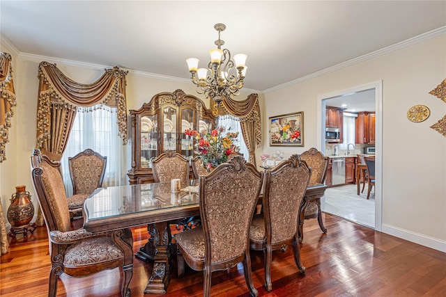 dining space featuring hardwood / wood-style flooring, crown molding, and a chandelier