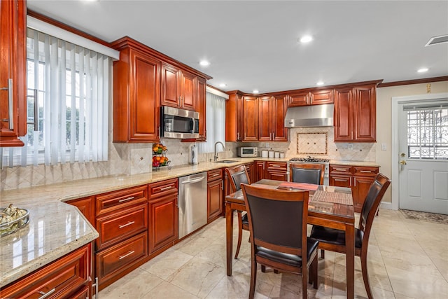 kitchen with sink, crown molding, decorative backsplash, light stone counters, and stainless steel appliances