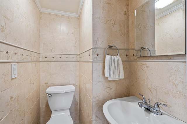 bathroom featuring toilet, tile walls, crown molding, and sink