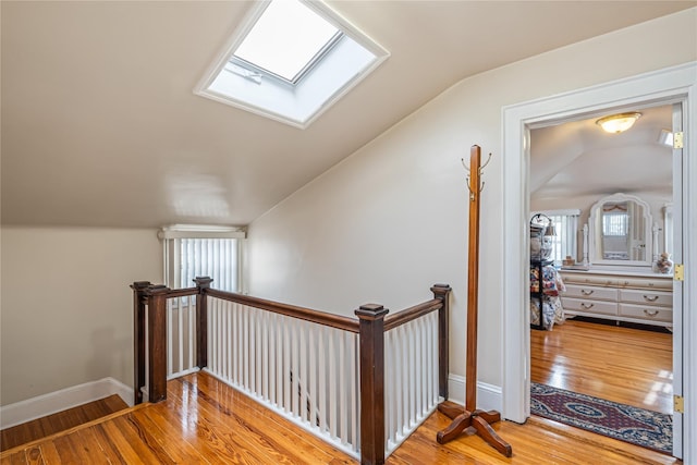 interior space with wood-type flooring and lofted ceiling with skylight