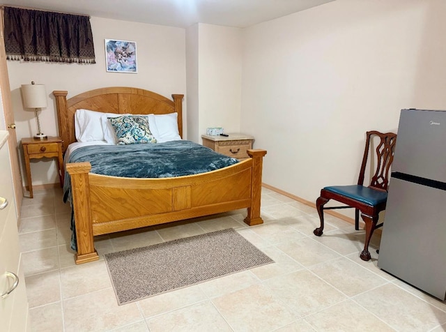 bedroom featuring tile patterned floors and stainless steel refrigerator