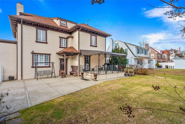 back of property featuring a yard and a patio