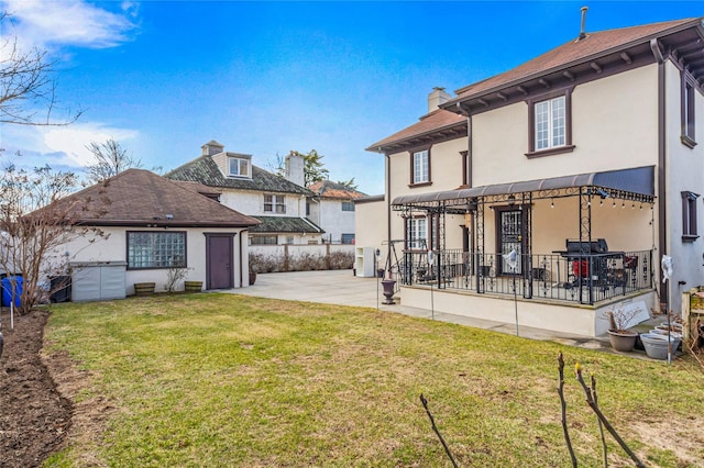 back of property featuring a patio area and a yard