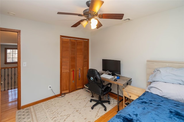 bedroom with light wood-type flooring, a closet, and ceiling fan