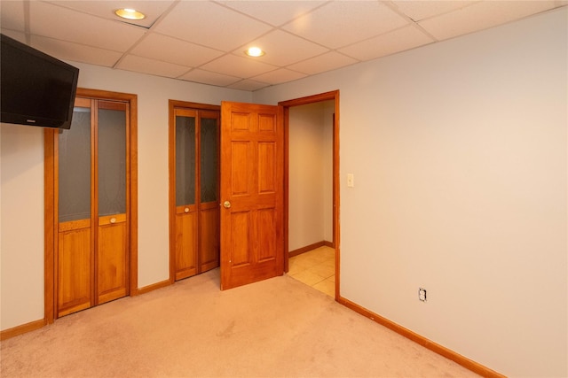 unfurnished bedroom with light colored carpet and two closets