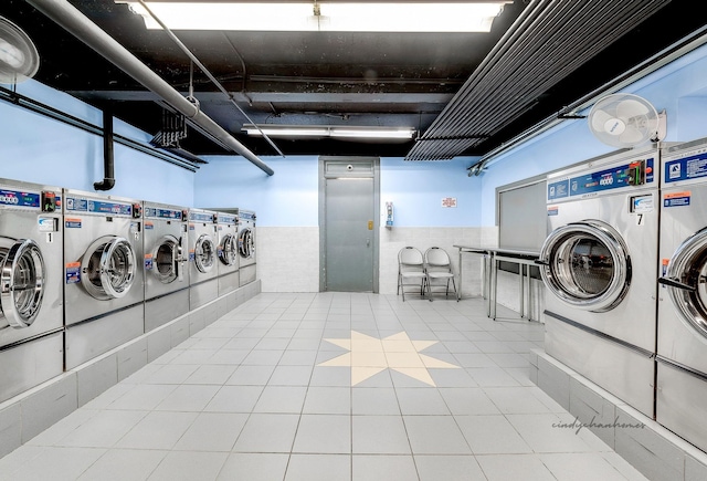 laundry area with washer and dryer and light tile patterned floors