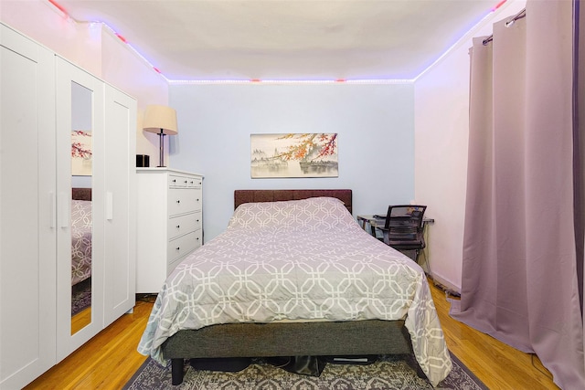 bedroom with crown molding and light hardwood / wood-style floors