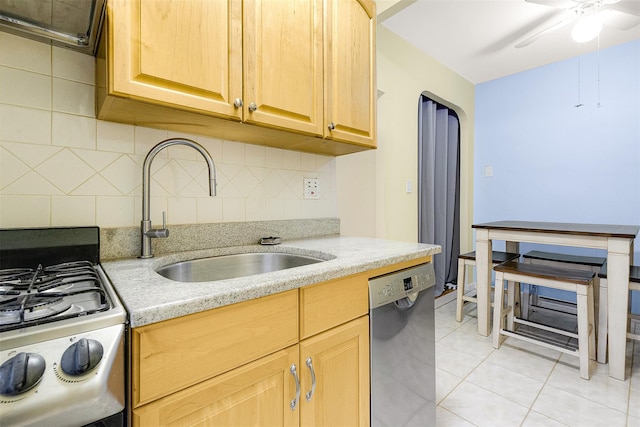 kitchen with gas stove, sink, tasteful backsplash, stainless steel dishwasher, and light tile patterned floors