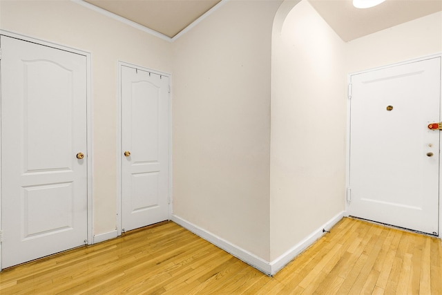 foyer entrance featuring ornamental molding and light hardwood / wood-style flooring