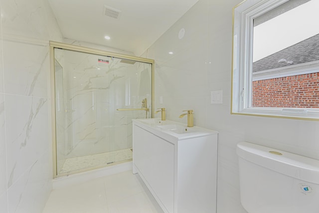 bathroom featuring toilet, a shower with shower door, tile walls, tile patterned floors, and vanity