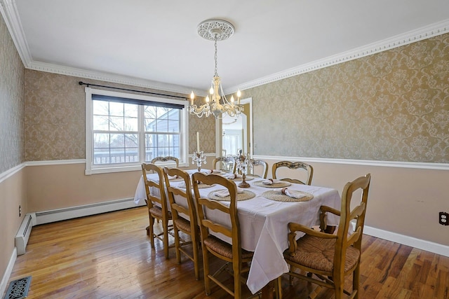 dining room with light hardwood / wood-style floors, baseboard heating, ornamental molding, and an inviting chandelier