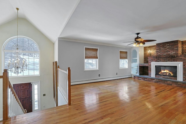 unfurnished living room with light hardwood / wood-style floors, a brick fireplace, a baseboard radiator, vaulted ceiling, and ceiling fan with notable chandelier