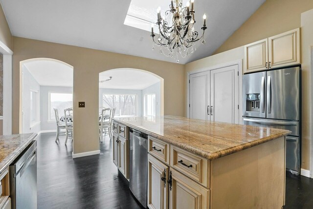 kitchen with light stone countertops, dark hardwood / wood-style flooring, stainless steel appliances, and a kitchen island