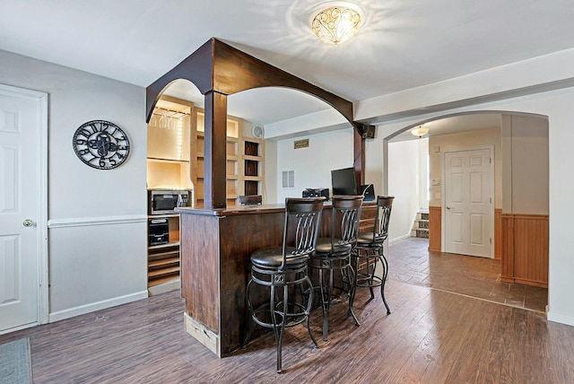 kitchen featuring dark wood-type flooring and a breakfast bar area