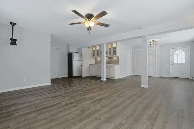 unfurnished living room with ceiling fan and dark hardwood / wood-style flooring