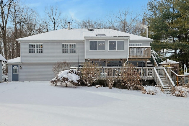 snow covered property with a wooden deck