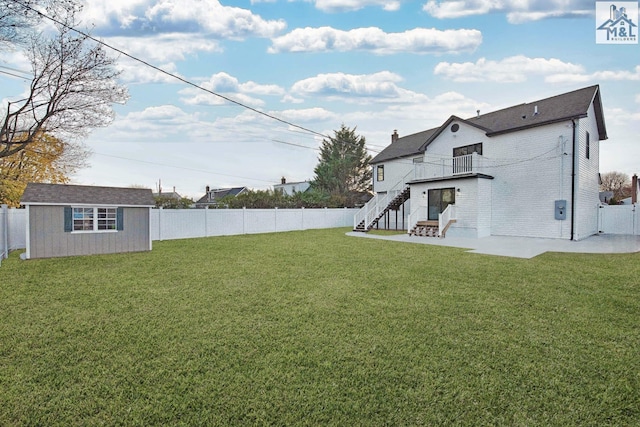 view of yard with a patio, a balcony, and a storage shed