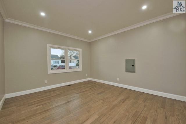 unfurnished room featuring electric panel, crown molding, and hardwood / wood-style floors