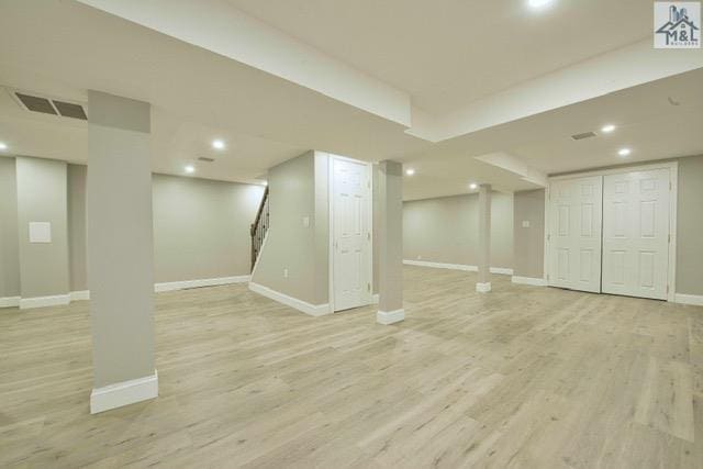 basement with light hardwood / wood-style flooring