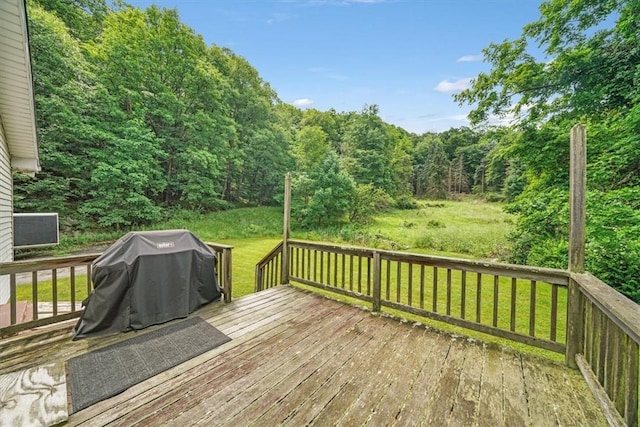 wooden terrace featuring grilling area and a yard