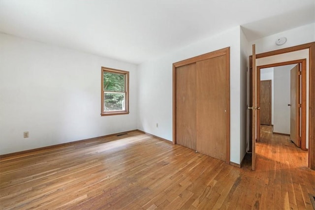 unfurnished bedroom featuring a closet and light hardwood / wood-style flooring