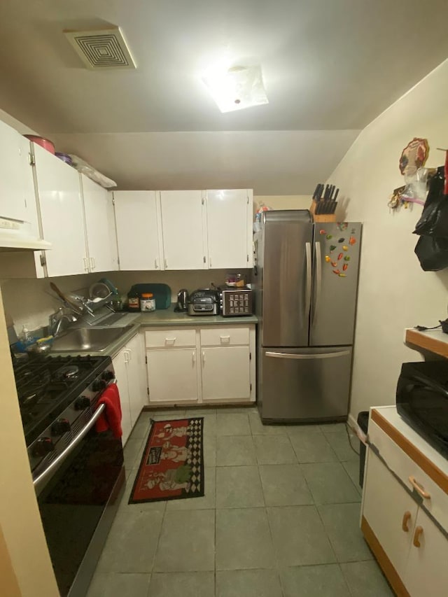 kitchen with white cabinets, appliances with stainless steel finishes, extractor fan, and sink