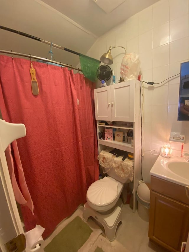 bathroom with vanity, toilet, walk in shower, and tile walls